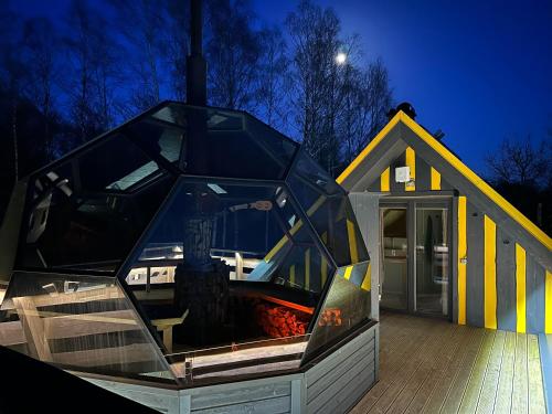 uma casa com uma caixa de vidro em frente em Lepikumäe Holiday Home with Sauna and Hot tub for up to 16 persons em Reina