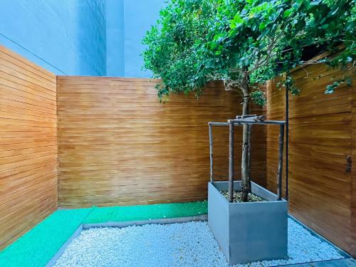 a tree in a pot next to a wooden fence at Woodstory Boutique Hotel in Bangkok