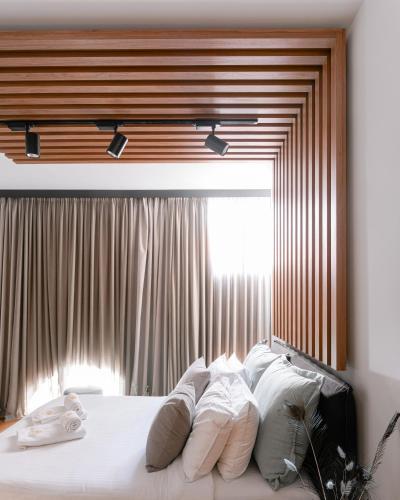 a bedroom with a bed with white pillows and a window at Snob Athens in Athens