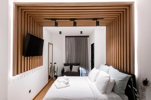 1 dormitorio con 1 cama y TV en la pared en Snob Athens, en Atenas
