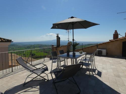 Un patio con una mesa y sillas y una sombrilla. en Scappo in Umbria, La Terrazza, en Lugnano in Teverina