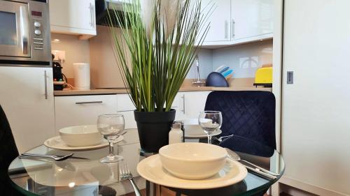 a dining table with two glasses and a potted plant at Notting Hill- The One One One! -5- in London
