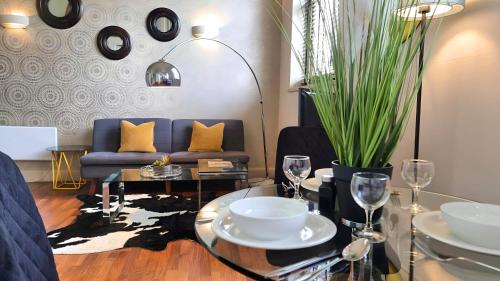 a living room with a blue couch and a table with glasses at Notting Hill- The One One One! -5- in London