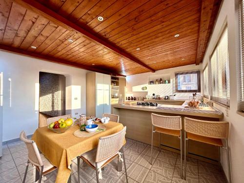 cocina y comedor con mesa y sillas en "THE ATTIC" - Appartamento Esclusivo con Parcheggio Gratuito, en Marano di Napoli