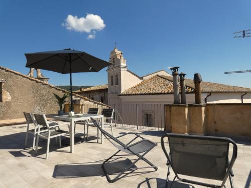 eine Terrasse mit einem Tisch, Stühlen und einem Sonnenschirm in der Unterkunft Scappo in Umbria, La Terrazza in Lugnano in Teverina