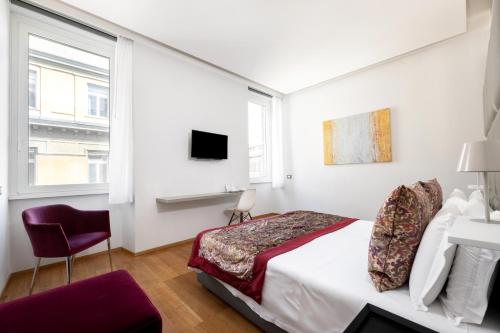 um quarto branco com uma cama e uma cadeira em Mascherino Suites em Roma