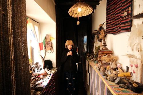 Panorama Inn Mustang في Muktināth: امرأة تقف في مرآة في غرفة مع الحيوانات المحشوة