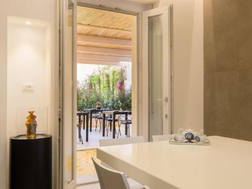 una cocina con mesa y sillas y una puerta corredera de cristal en CeO LUXURY SUITE DI CAGLIARI, en Cagliari