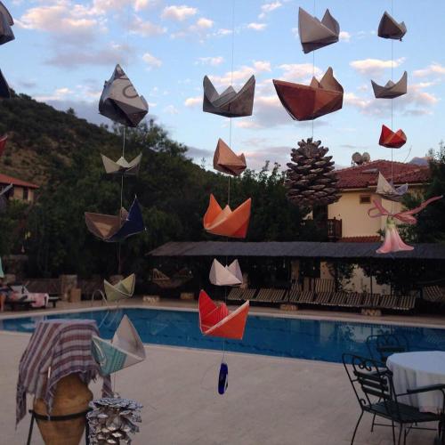 a bunch of umbrellas hanging over a swimming pool at Misafir Evi in Kayakoy