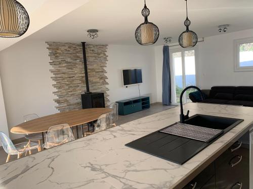 une cuisine et un salon avec une table et un canapé dans l'établissement Maison lumineuse aux portes de Montpellier, à Vailhauquès