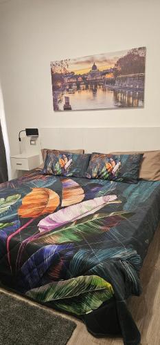 uma cama com um edredão colorido num quarto em Vittoria's rooms em Roma