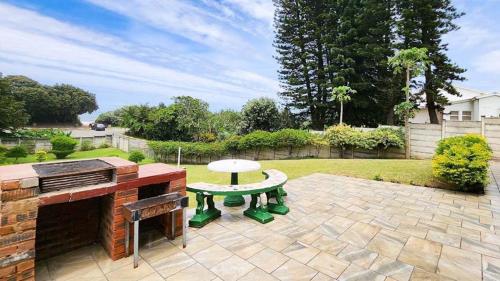 un patio con mesa y parrilla en Sea Park Holi-Stay - 2on1stAve, en Port Shepstone