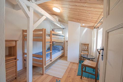 a bedroom with bunk beds and a table and a chair at Plan B Appartementen in Bad Kleinkirchheim