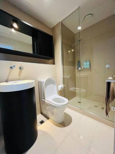 a bathroom with a toilet and a glass shower at Abbotsford Apartment: Yarra River & CBD nearby in Melbourne