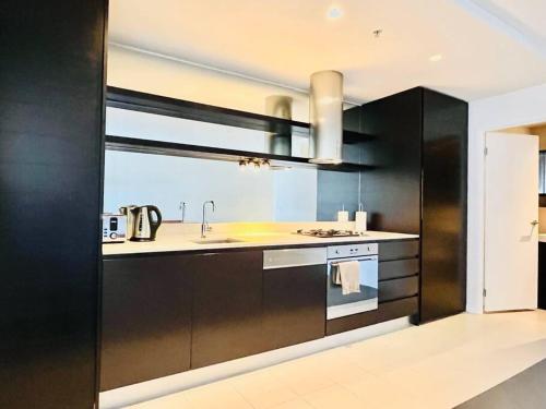 a kitchen with a sink and a stove at Abbotsford Apartment: Yarra River & CBD nearby in Melbourne