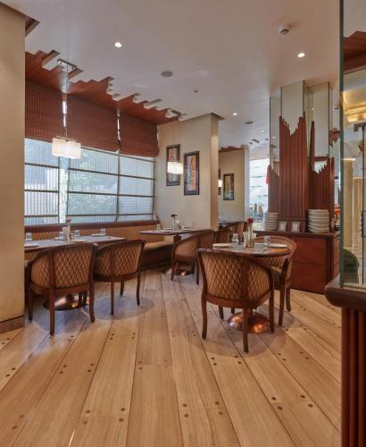 a restaurant with wooden floors and tables and chairs at Hotel Residency Andheri in Mumbai
