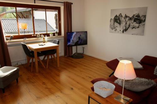 uma sala de estar com um sofá e uma mesa em Isarkindl em Krün