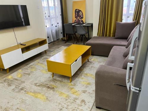 a living room with a couch and a tv at SuperhostHomes AirBnbs Nakuru in Nakuru