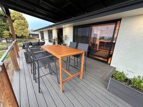 een houten tafel en stoelen op een terras bij The Hilltop, spacious family retreat with views! in Port Lincoln