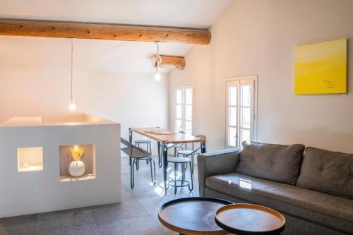 ein Wohnzimmer mit einem Sofa und einem Tisch in der Unterkunft La Maison Favier in Saint-Rémy-de-Provence