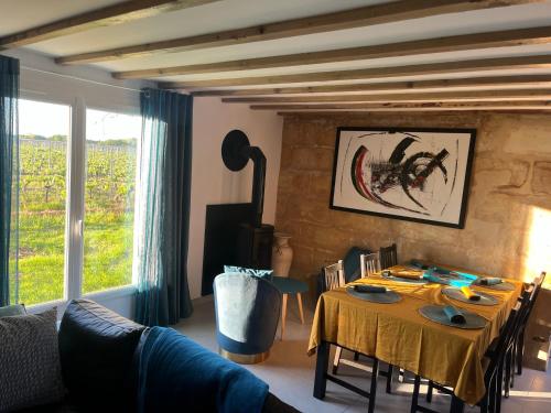 un salon avec une table et un chiffon de table jaune dans l'établissement Gîte du Ferrand au coeur des vignes, à Montagne