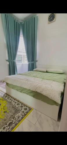 - une chambre avec un lit doté de rideaux bleus et d'une fenêtre dans l'établissement Ombak Cottage, à Bachok
