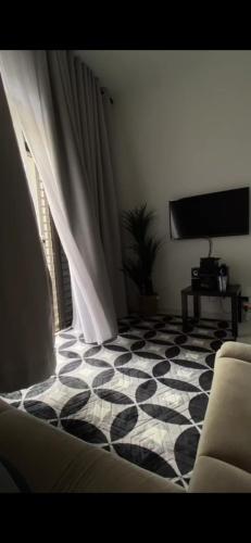 - un salon avec un sol en damier noir et blanc dans l'établissement Ombak Cottage, à Bachok