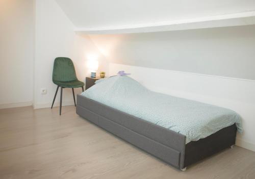 ブローニュ・シュル・メールにある++++ CENTRAL DUPLEX RENOVE 5 PIECES 150M2 A 8 MN DE LA PLACE DALTON ++++のベッドルーム1室(ベッド1台、緑の椅子付)