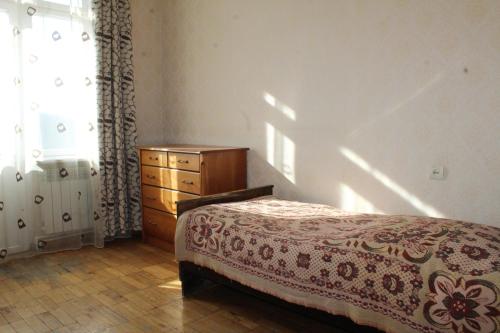 een slaapkamer met een bed, een dressoir en een raam bij Вид на Арарат in Jerevan