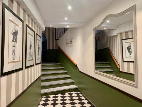 um corredor com escadas e um piso em xadrez em Hotel Central Bastia em Bastia