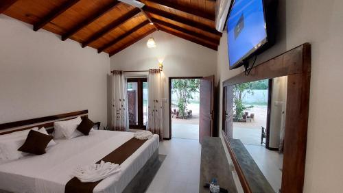 a bedroom with two beds and a flat screen tv at The Dream Inn Guesthouse Passikudah in Batticaloa