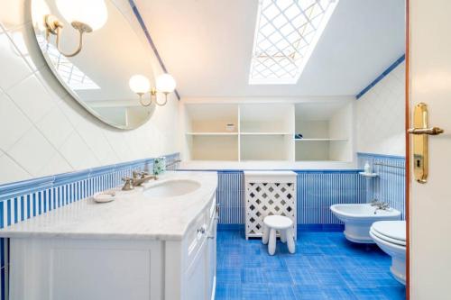 een badkamer met een wastafel en een spiegel bij Villa Olivia in Forte dei Marmi