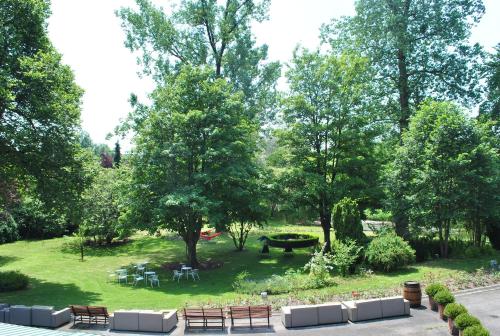 a park with benches and tables and trees at Résidence de la Roseraie in Florenville