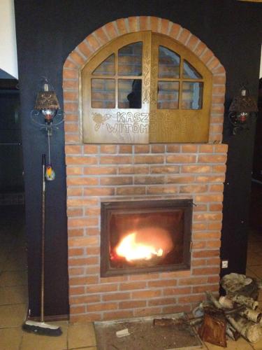 a brick fireplace with a fire in it at Dom Kaszubski in Bytów
