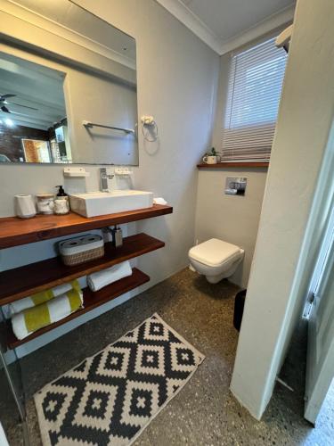 a bathroom with a sink and a toilet and a mirror at The Facebrick Flat in East London
