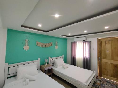 2 Betten in einem Zimmer mit grünen Wänden in der Unterkunft DOWNTOWN RESORT SANTA FE in Santa Fe