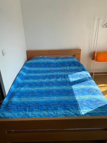 Bett mit blauer Decke in einem Zimmer in der Unterkunft Love birds place in Skopje