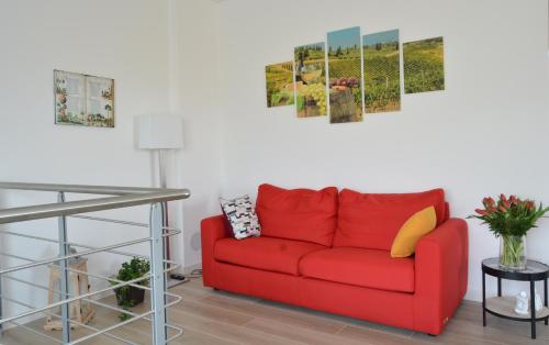 a red couch in a living room with a table at La Collina del Poeta in Arqua Petrarca