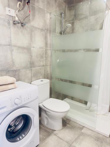 a bathroom with a toilet and a washing machine at KAI Apartment Playa Paraiso in Playa Paraiso