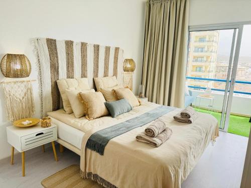 a bedroom with a large bed and a large window at KAI Apartment Playa Paraiso in Playa Paraiso