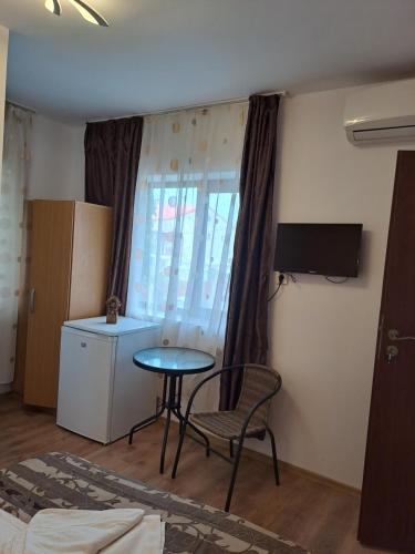 a room with a table and a chair and a window at Casa Ancuta in Eforie Sud