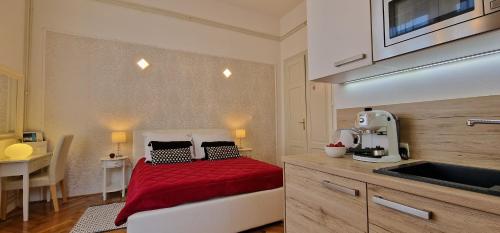 a bedroom with a bed with a red bedspread on it at Apartment Medea 2 with private parking in Opatija
