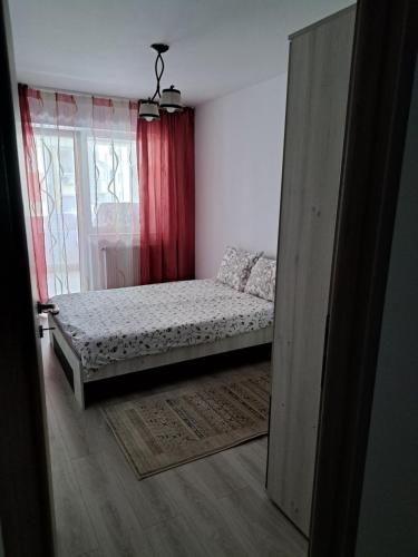 a small bedroom with a bed and a window at Fiald Apartament nou in Bacău