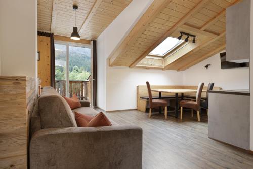 a living room with a couch and a table at Dolomite Apartments - by Familiaris in San Candido