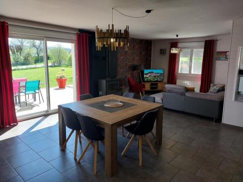 un salon avec une table et des chaises en bois dans l'établissement Entre Lacs Et Montagnes , Maison individuelle,lits préparés, parking et ménage inclus, à Barésia-sur-lʼAin