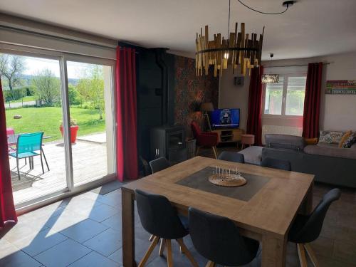 uma sala de estar com uma mesa de madeira e cadeiras em Entre Lacs Et Montagnes , Maison individuelle, lits préparés et ménage inclus em Barésia-sur-lʼAin