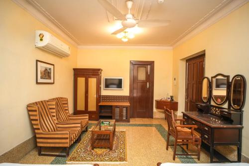 a living room with a couch and a table at Nilambag Palace Hotel in Bhavnagar