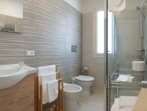 a bathroom with a sink and a toilet and a shower at mya luxury rooms and wellness in Melendugno
