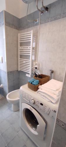 a washing machine in a bathroom with a toilet at Margot's House Rho in Rho