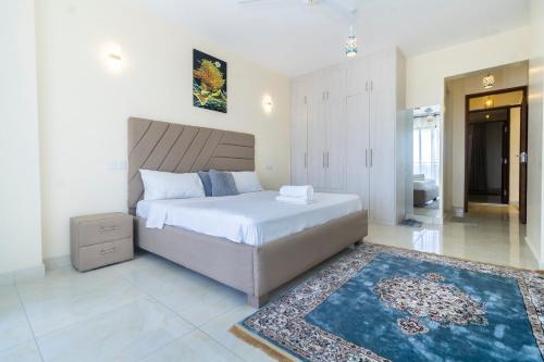 a bedroom with a large bed and a rug at Mombasa Nyali Beachfront Apt in Mombasa